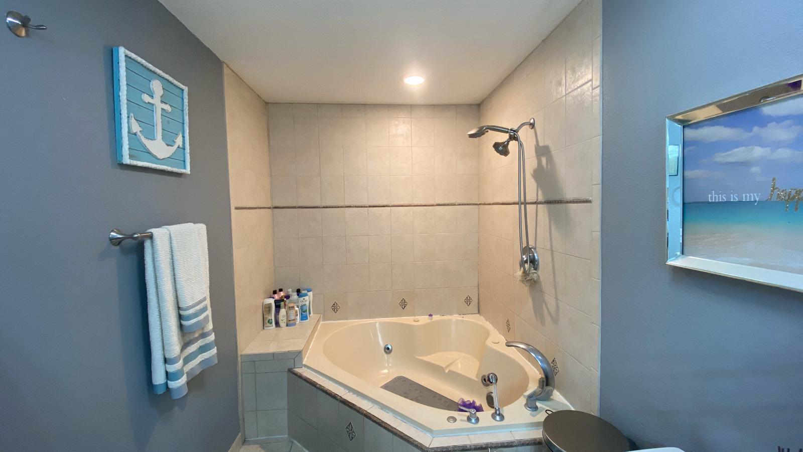 2628 Marcinski Road Jupiter, FL 33477 - Photo 8 of 18 a bathroom with a tub a window and a shower