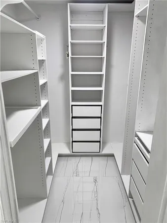 a view of walk in closet with empty racks
