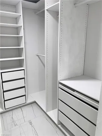 a view of walk in closet with empty racks