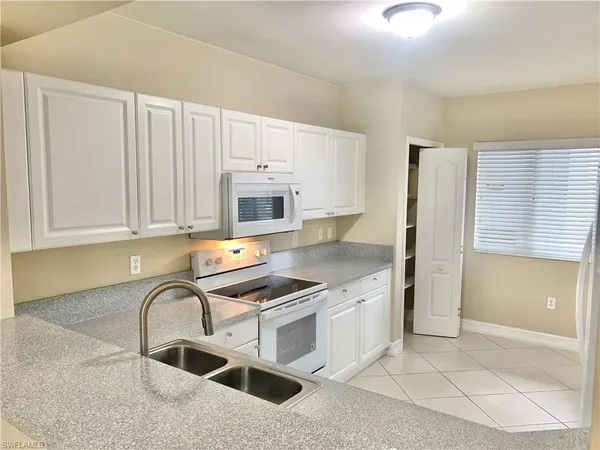 a kitchen with granite countertop a stove a sink and a microwave