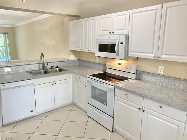 a kitchen with white cabinets and white appliances
