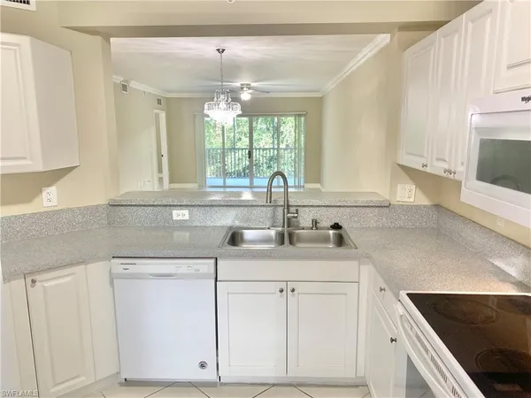 a kitchen with white cabinets and white appliances