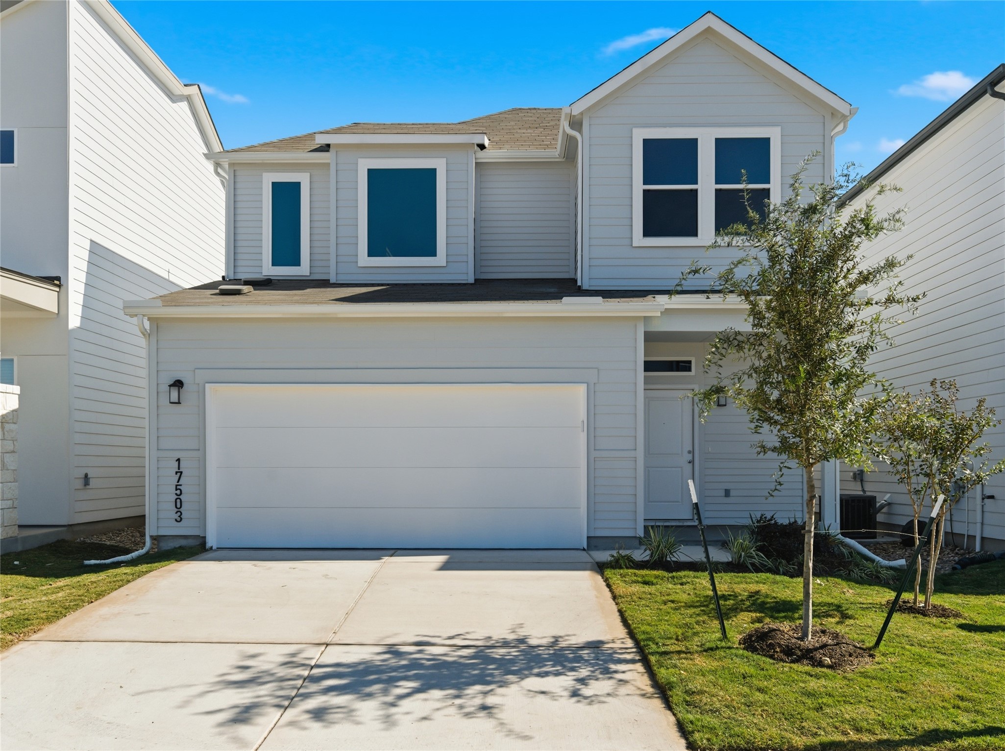 Traditional-style home featuring driveway, a garage, roof with shingles, and a front lawn. Photos are representative not actual.