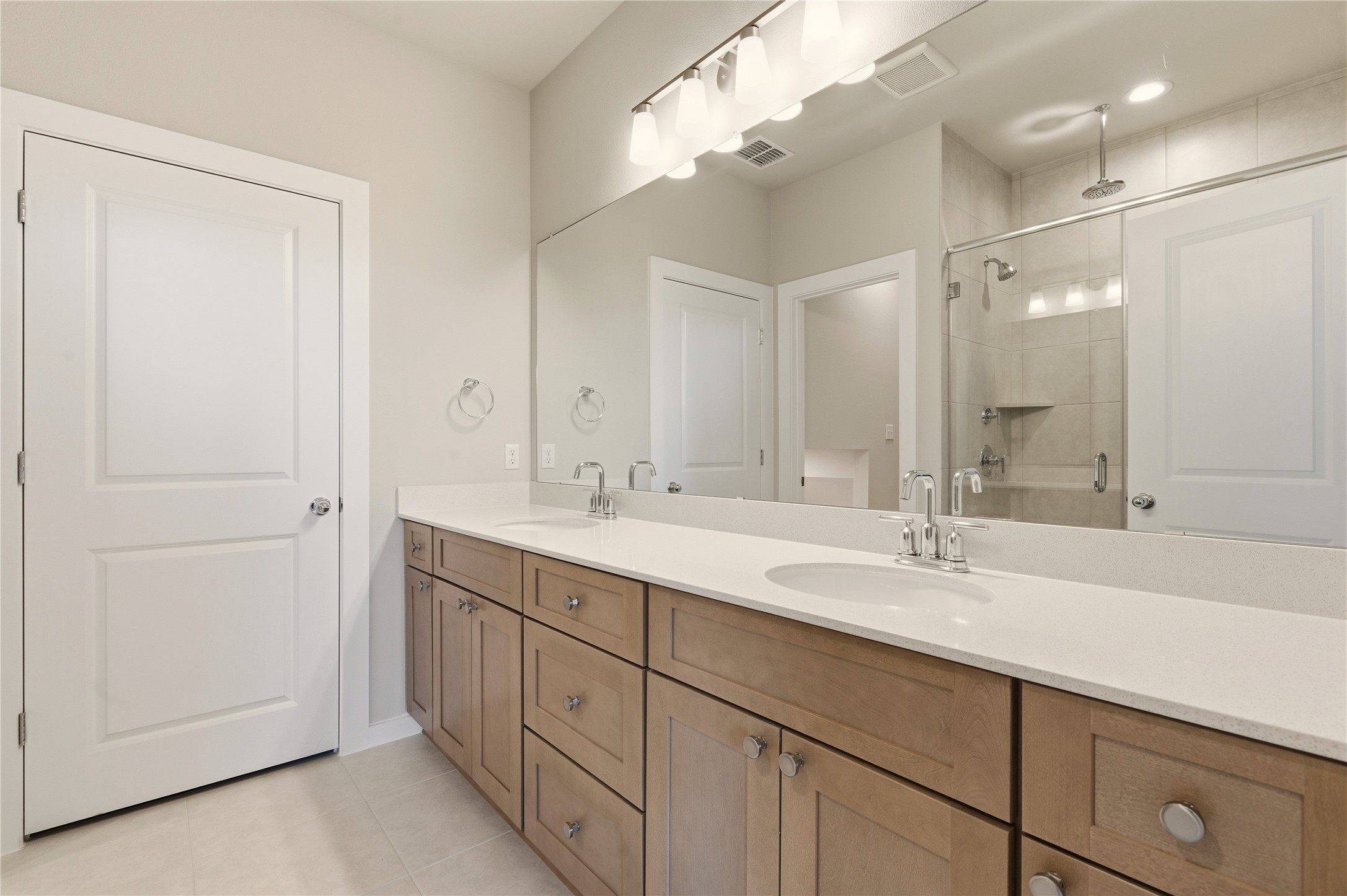 2201 Cento Walk Round Rock, TX 78664 - Photo 14 of 30 Bathroom with double vanity, a shower stall, and light tile patterned floors