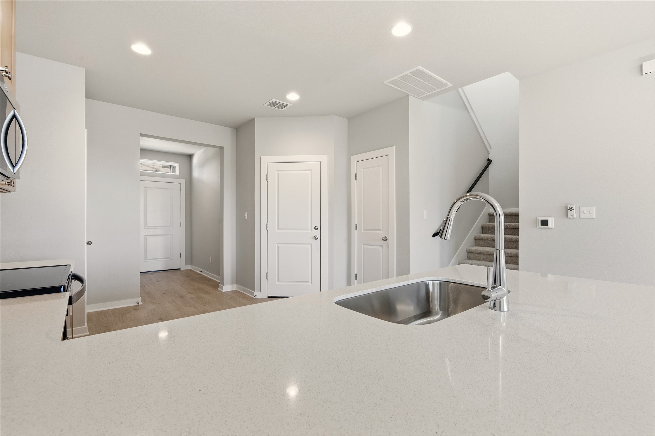 2201 Cento Walk Round Rock, TX 78664 - Photo 7 of 30 Kitchen with recessed lighting, light stone counters, stainless steel microwave, light wood-type flooring, and black electric range
