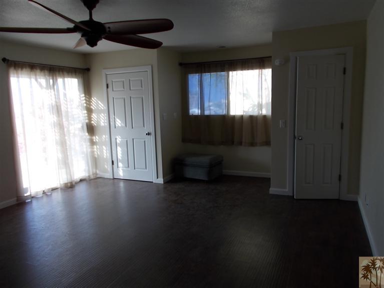 12478 Redbud Road Desert Hot Springs, CA 92240 - Photo 18 of 21 a view of an empty room with wooden floor and a window