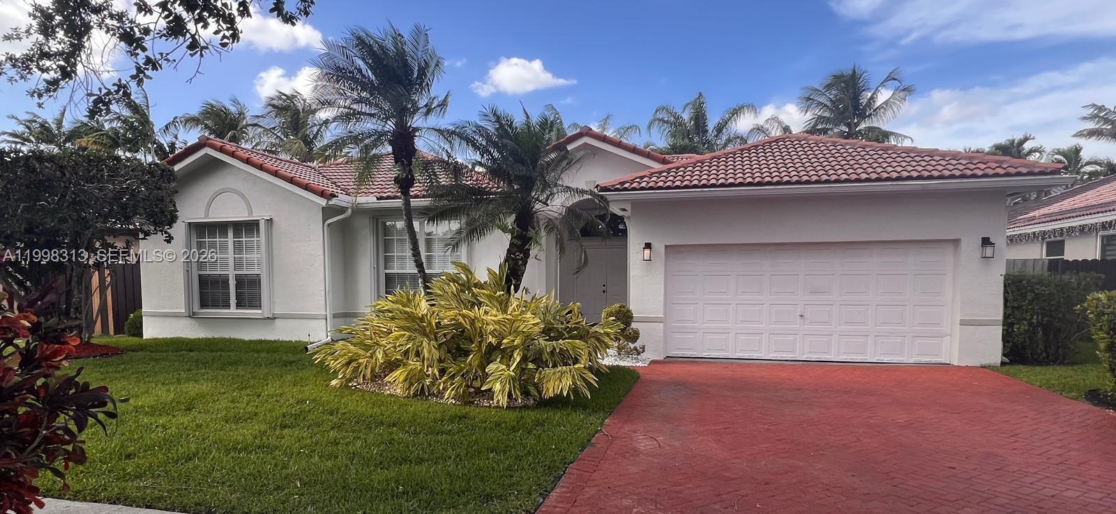 15761 Southwest 148th Terrace Miami, FL 33196 - Photo 1 of 17 a front view of a house with a garden and yard