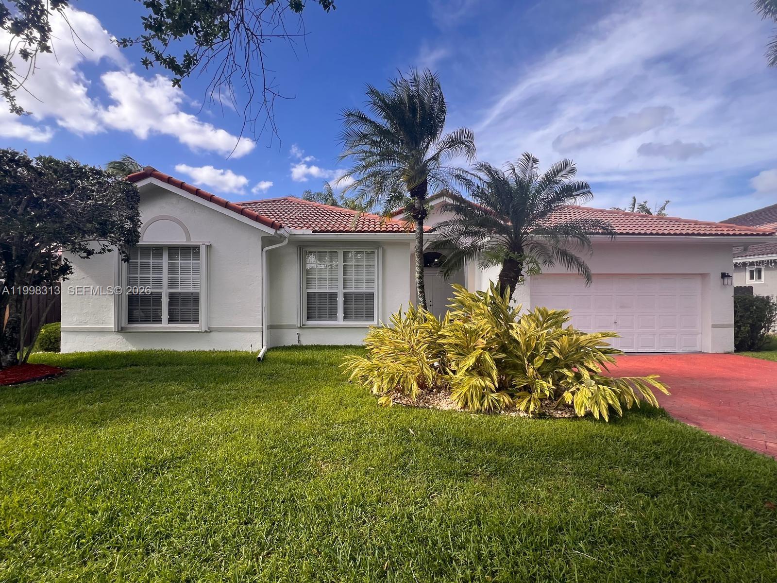 15761 Southwest 148th Terrace Miami, FL 33196 - Photo 2 of 17 a front view of house with yard and outdoor seating