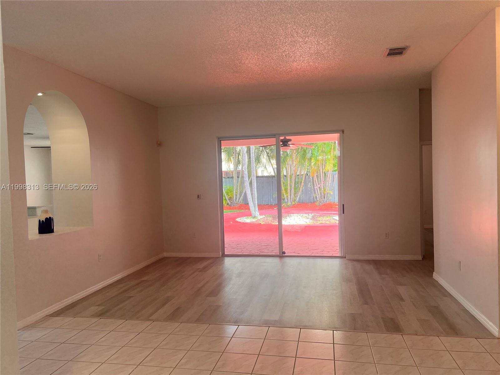 15761 Southwest 148th Terrace Miami, FL 33196 - Photo 3 of 17 an empty room with wooden floor and windows