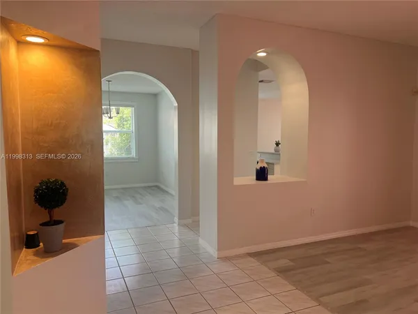 a view of a hallway with wooden floor and a bathroom