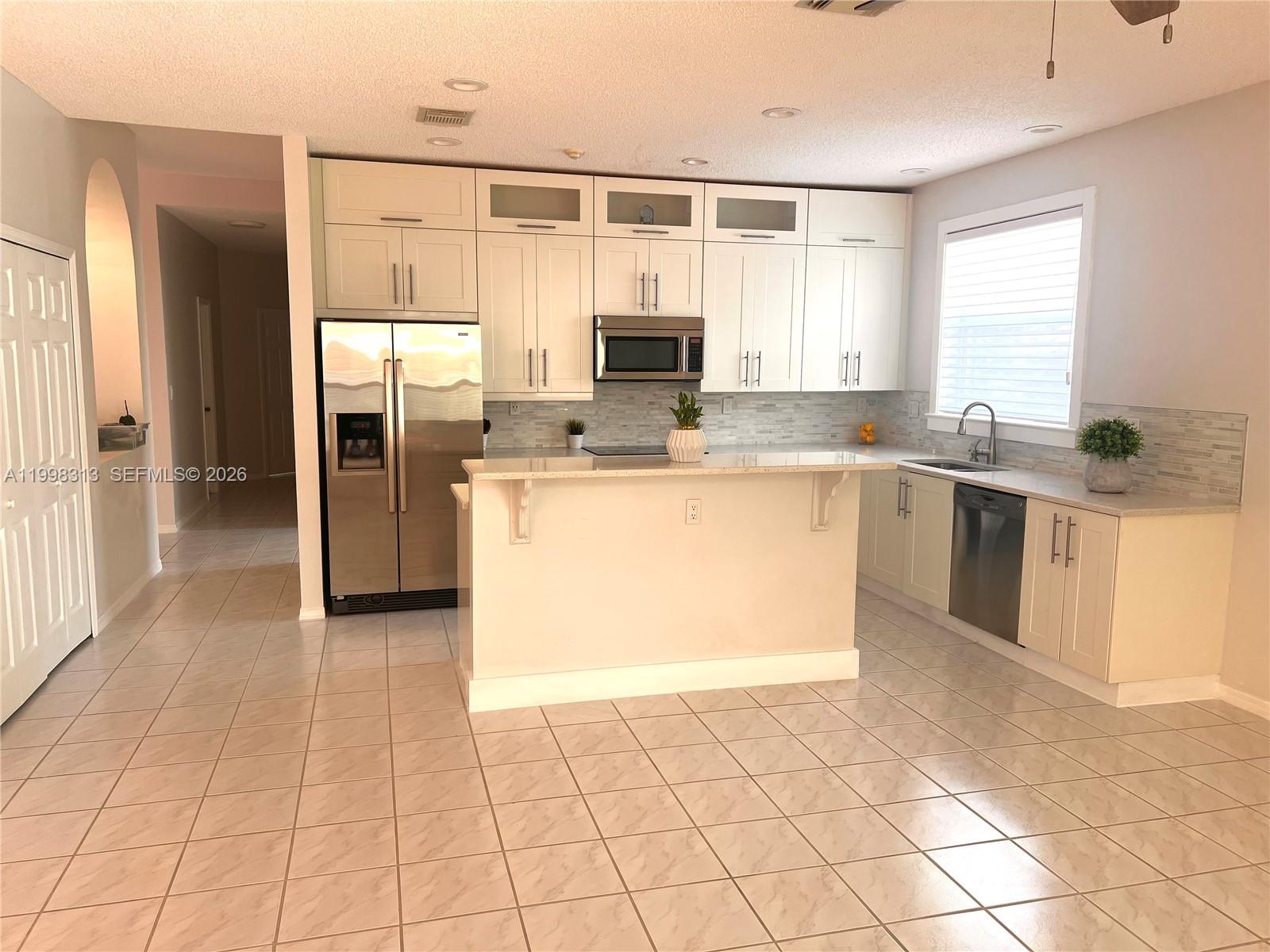 15761 Southwest 148th Terrace Miami, FL 33196 - Photo 9 of 17 a kitchen with stainless steel appliances granite countertop a stove top oven a sink a counter top space and cabinets