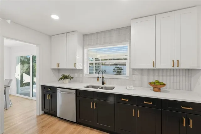 a kitchen with stainless steel appliances granite countertop a sink a stove and cabinets
