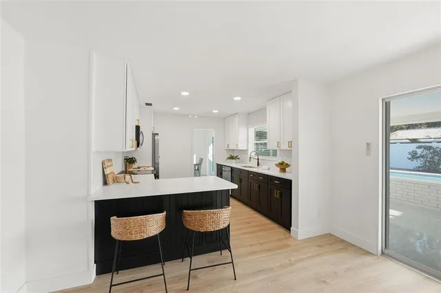 a kitchen with a sink and chairs