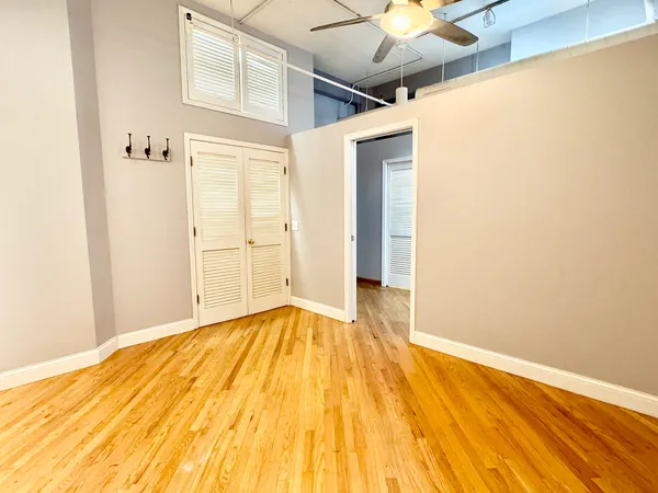 a view of a room with wooden floor and a ceiling fan