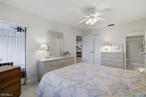 a spacious bedroom with a bed and a chandelier