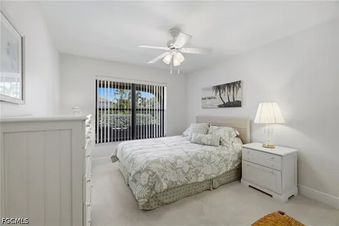 a bedroom with a bed a chandelier and a window