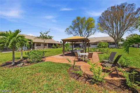 a view of a patio with a table and chairs under an umbrella
