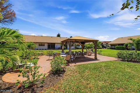 a view of a patio with table and chairs under an umbrella