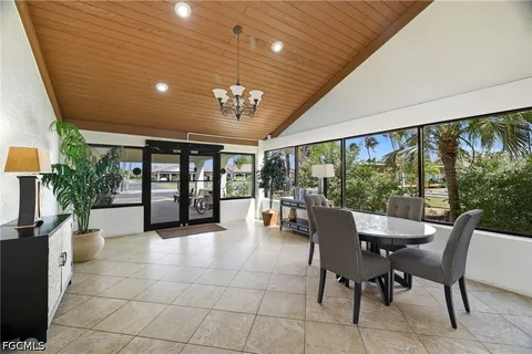 a dining room with furniture a chandelier and fireplace