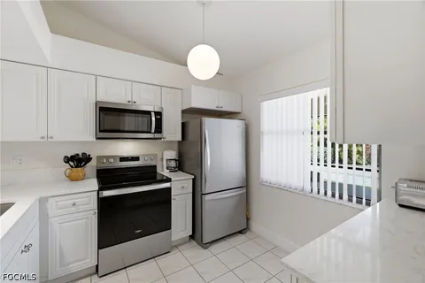 a kitchen with a refrigerator stove and white cabinets