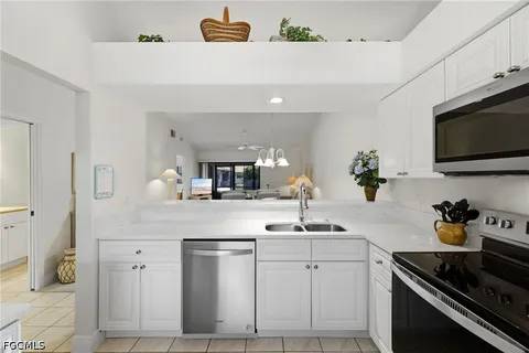 a kitchen with white cabinets and appliances