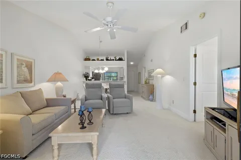 a living room with furniture a chandelier and a flat screen tv