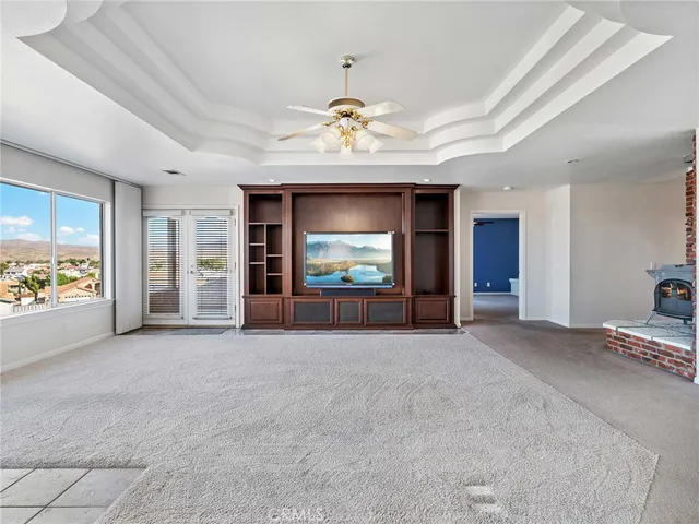 a view of an empty room with a window and a kitchen