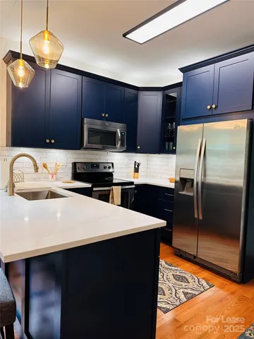 a kitchen with stainless steel appliances a refrigerator a sink a stove a microwave and island