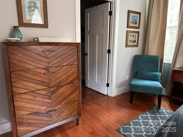 a view of a bedroom with furniture and wooden floor