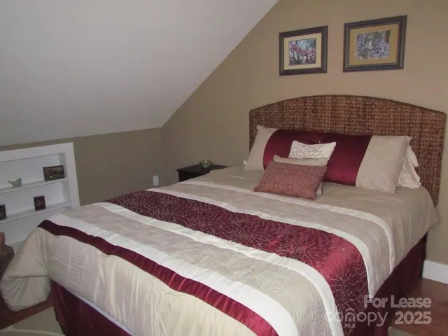 a bedroom with a bed and painting on the wall