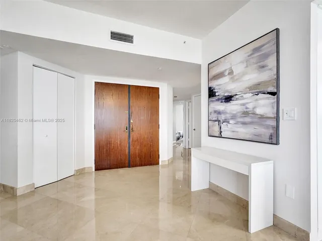 a kitchen with stainless steel appliances granite countertop a refrigerator a sink a stove and white cabinets