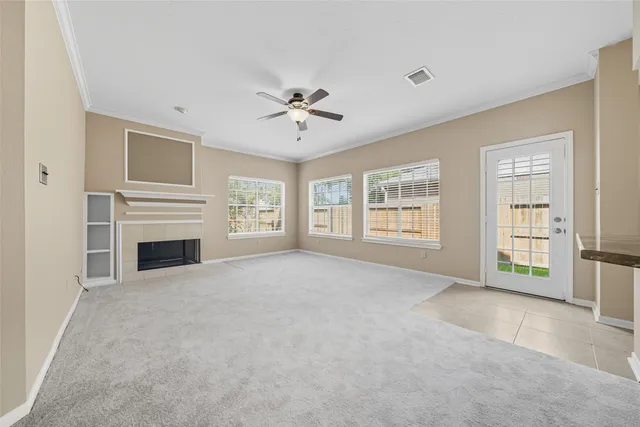 a view of an empty room with a fireplace and a window