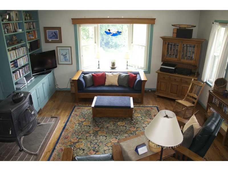225 Wylie Road Saxonburg, PA 16056 - Photo 17 of 20 Living Room. Cozy Living Room with Bay Window, Built-In Book Shelves and Wood Burner