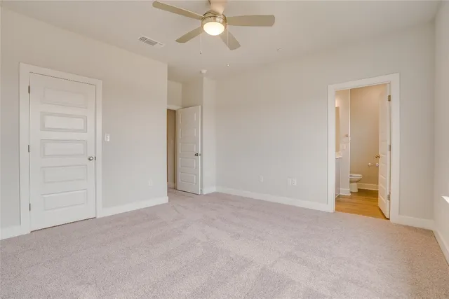 a view of an empty room and a ceiling fan window