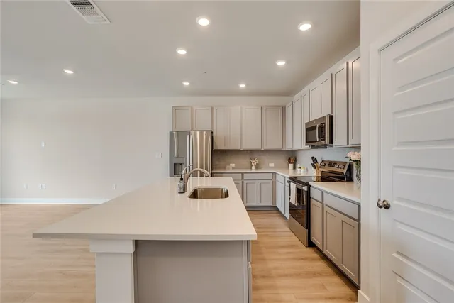 a kitchen with kitchen island white cabinets stainless steel appliances and sink