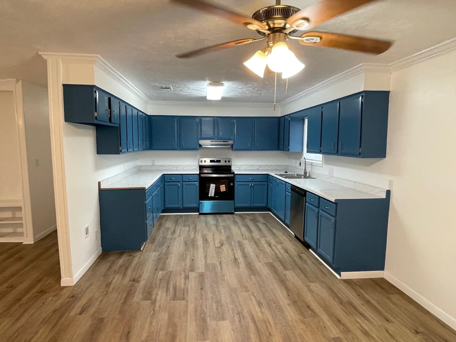 335 Carroll Road Richmond, TX 77469 - Photo 13 of 25 a kitchen with wooden floors and wooden cabinets
