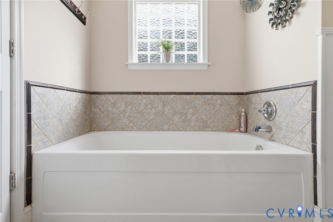 9433 Robin Road Disputanta, VA 23842 - Photo 23 of 26 White tub with tile surround featuring a decorativ