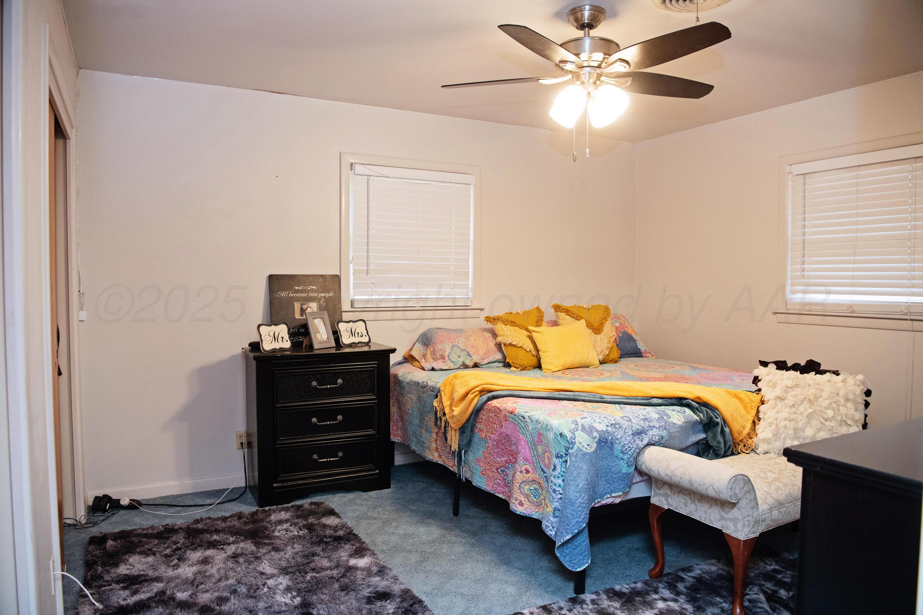 418 Star Street Hereford, TX 79045 - Photo 12 of 17 a bedroom with a bed and a chandelier