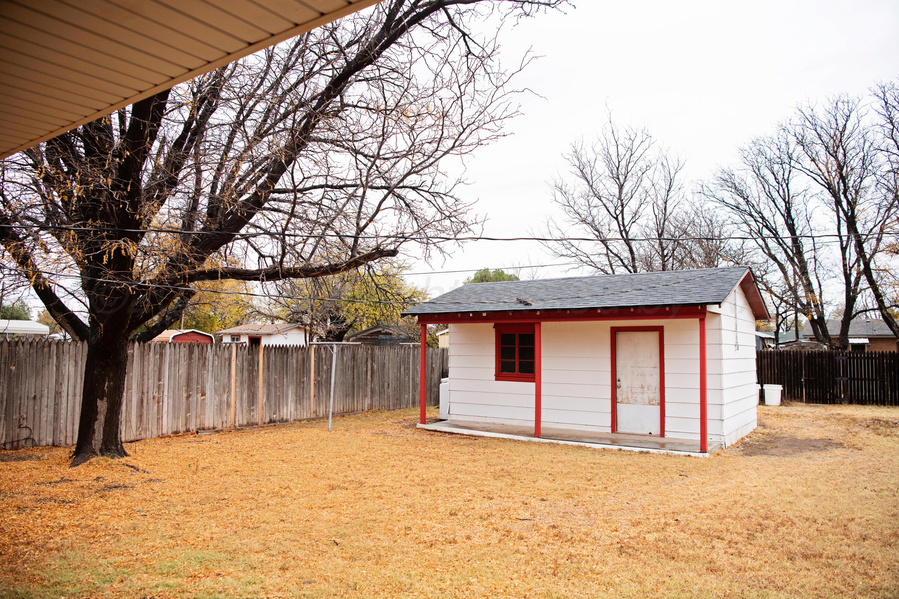 418 Star Street Hereford, TX 79045 - Photo 16 of 17 a backyard of a house with large trees and wooden fence