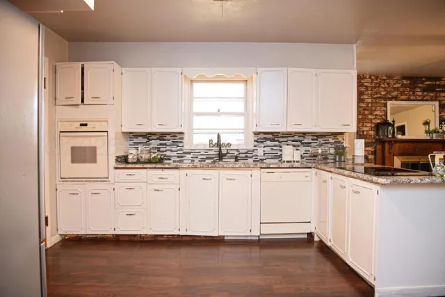 a kitchen with stainless steel appliances white cabinets and a window