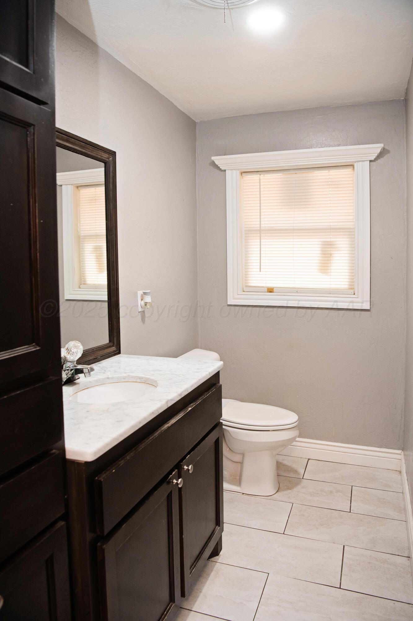 418 Star Street Hereford, TX 79045 - Photo 8 of 17 a bathroom with a granite countertop sink toilet and mirror