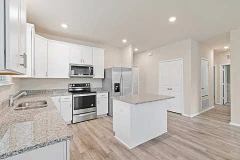 a kitchen with white cabinets and stainless steel appliances