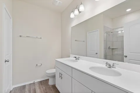 a bathroom with a granite countertop sink a toilet and a mirror