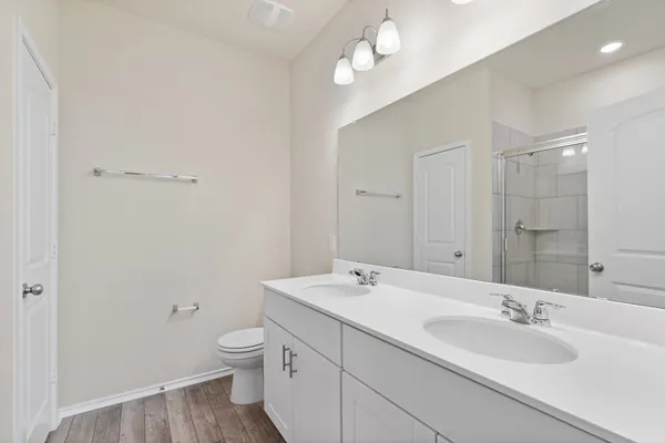 a bathroom with a granite countertop sink a toilet and a mirror
