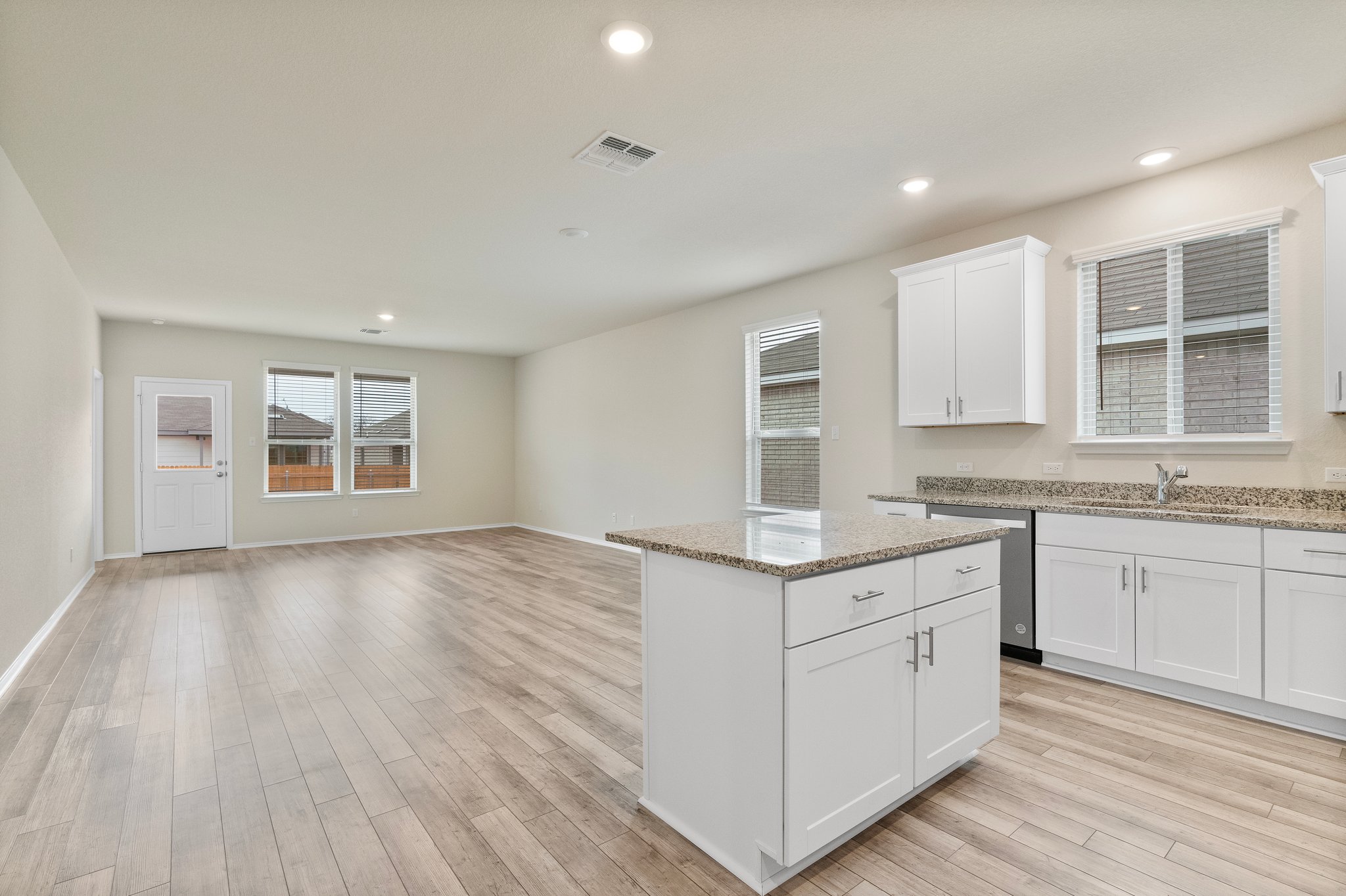 141 Onna Street Taylor, TX 76574 - Photo 7 of 26 a kitchen with a sink cabinets wooden floor and a window