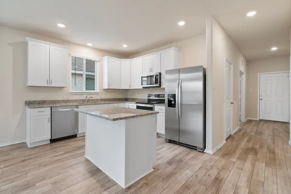 a kitchen with a refrigerator sink and cabinets