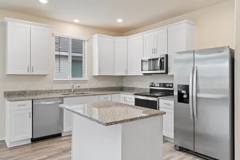 a kitchen with a refrigerator sink and microwave