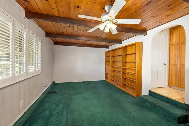 an empty room with windows and fireplace