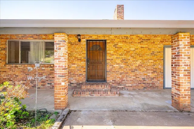 an empty room with windows and fireplace