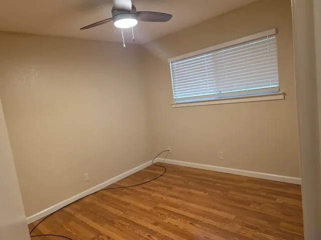 a view of a room with wooden floor and a window